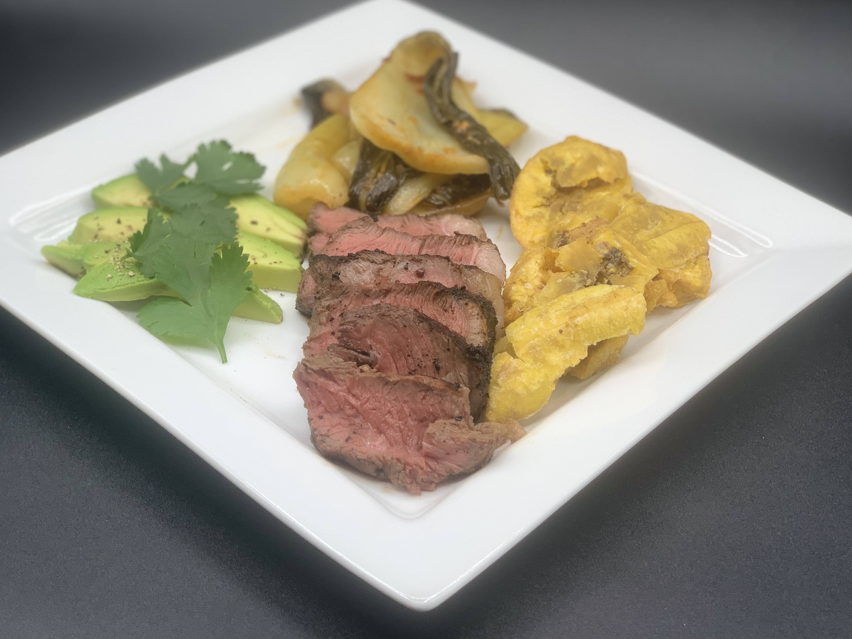 The prized cut of Brazil, Picanha, tenderized in a marinade that reflects the diverse cultural heritage of the South American nation, with notes of South East Asian flavors that emphasize the natural flavor of the beef, and served with crispy tostones and a savory stir-fried baby bok choy.